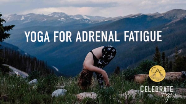 yoga for adrenal fatigue text with a view of emmy in forward fold on the top of a mountain