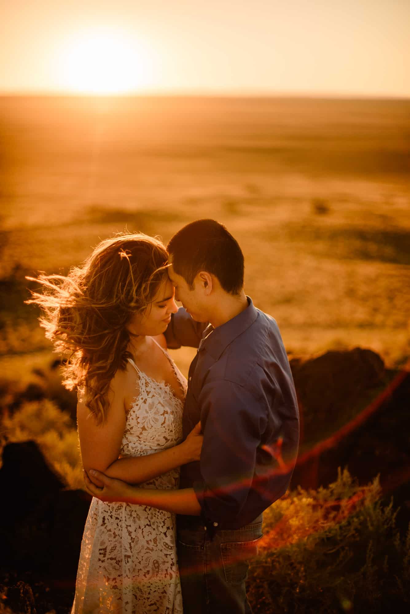 couple cuddling as the sunsets behind them