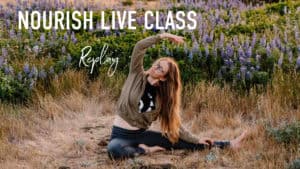 "nourish live class replay" emmy sitting in a field with wild flowers behind her in knee to nose side bend pose