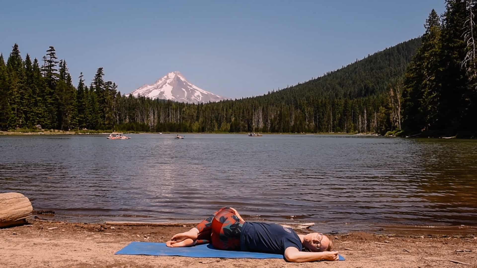 Emmy doing supine twist near an alpine lake for yoga to feel your best