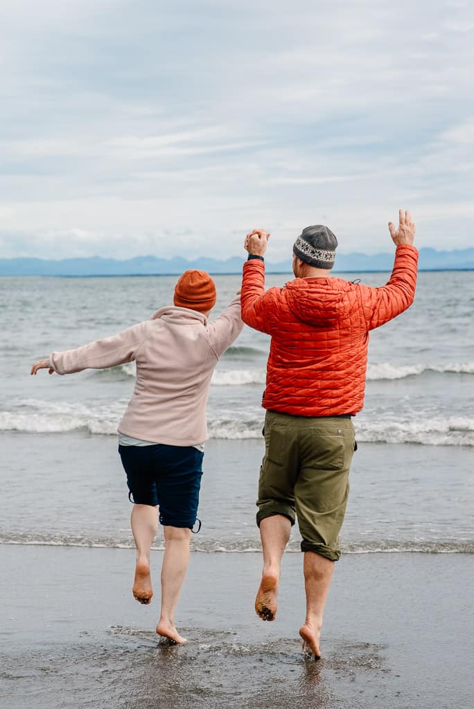 two people holding hands cheering into the ocean